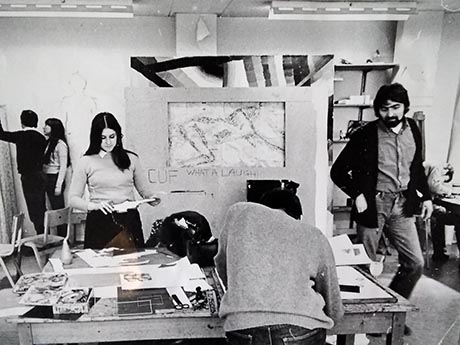 Black and white photo of five people working in an art studio