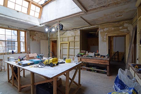 View of kitchen undergoing restoration showing work table and restored window.