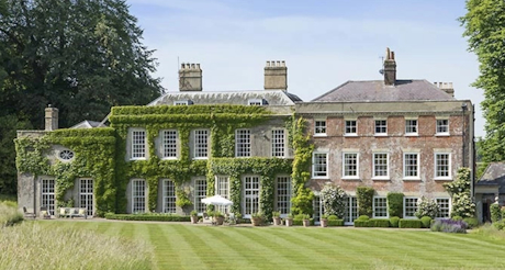 A colour photo of a grand country house