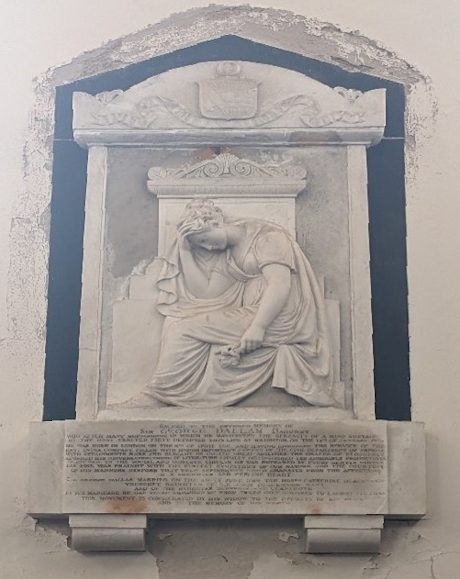 A colour photo of a carved memrial plaque in the church