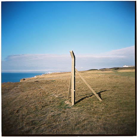 Photo of a concrete fence post standing close to a cliff edge