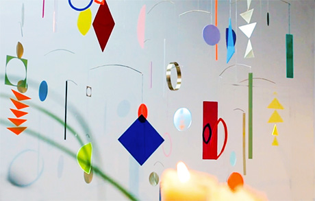 Photo of mobile comprising suspended coloured Perspex in a variety of geometreic shapes.